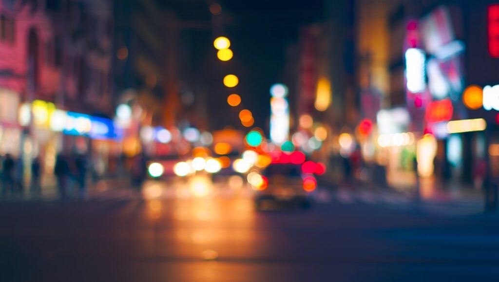 Visión borrosa nocturna en ciudad, posible percepción subjetiva durante episodios de temblor ocular causados por estrés visual.